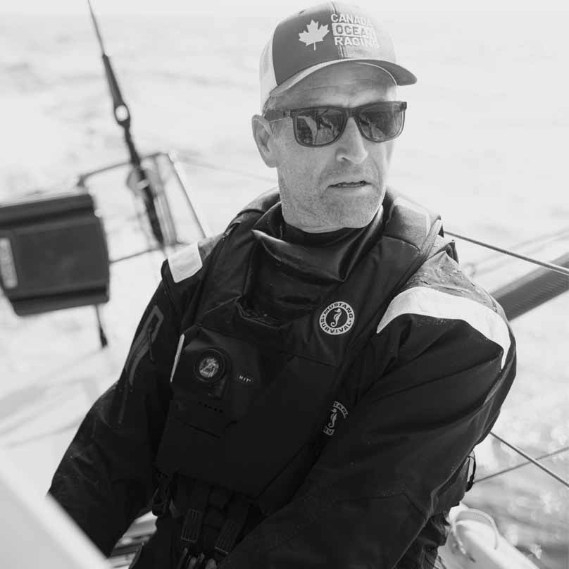 Black and white photo of Scott Shawyer in sailing gear, with a text quote praising the EP Smock and Salopettes.