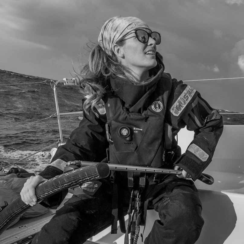 Black and white photo of Meg Reilly sailing, with a text quote praising the EP 6.5 Ocean kit's lightweight salopettes.