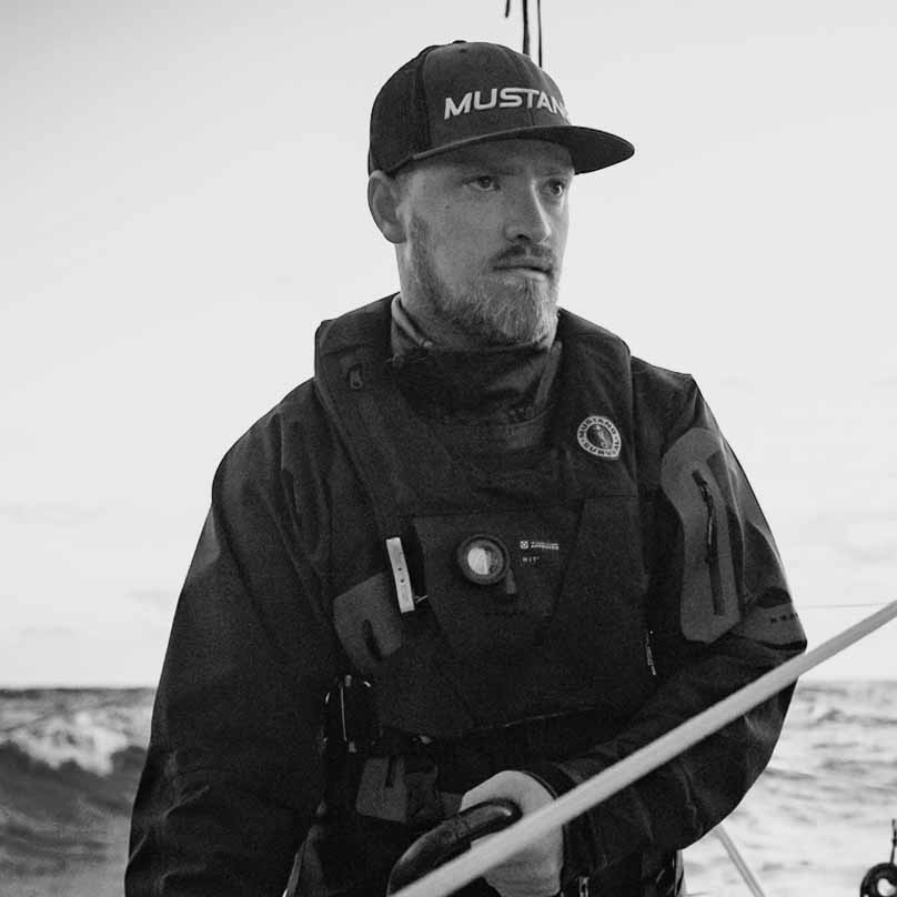 Black and white photo of Morgen Watson at sea, with a text quote praising the EP 6.5 Ocean Collection salopettes.
